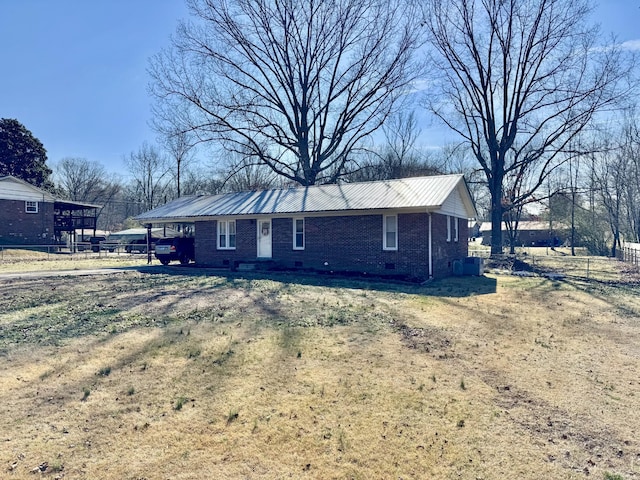 view of property exterior featuring crawl space, metal roof, a carport, and brick siding