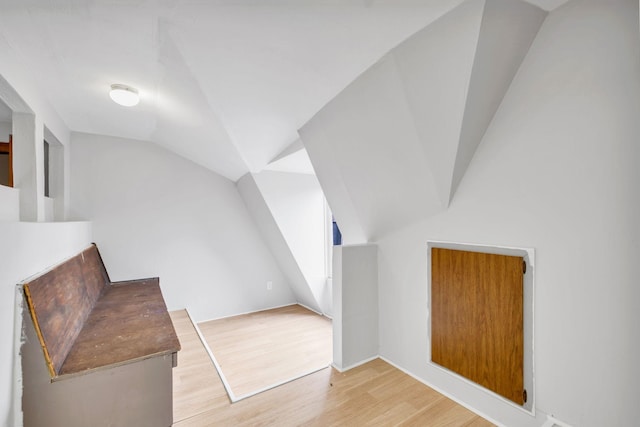 bonus room with wood-type flooring and vaulted ceiling