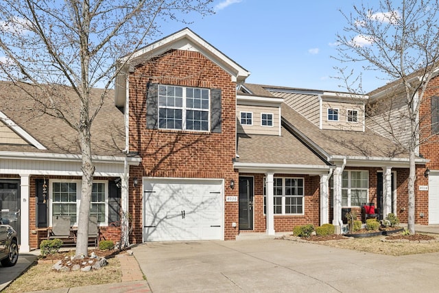 view of front of house featuring a garage, driveway, brick siding, and roof with shingles