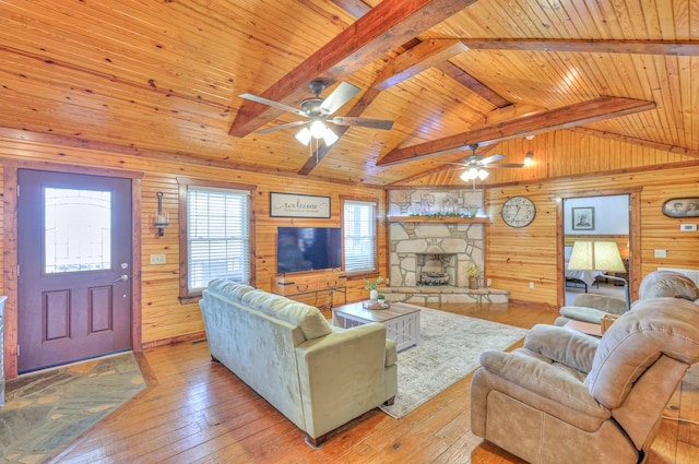 living room with wood ceiling, lofted ceiling with beams, light hardwood / wood-style floors, and wooden walls