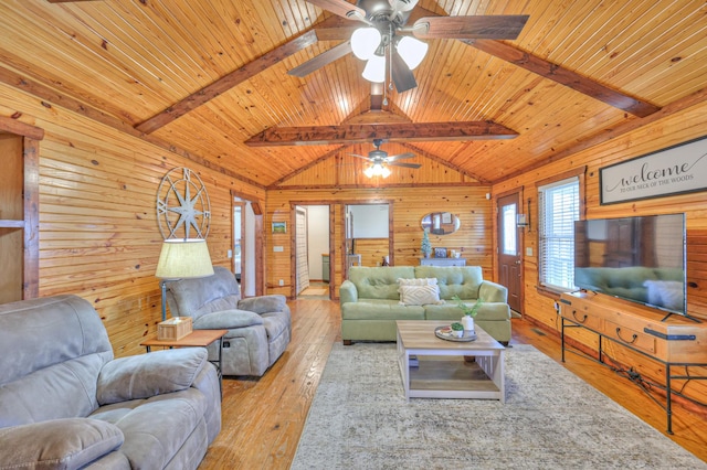 living room with vaulted ceiling with beams, wood ceiling, light wood-type flooring, and wood walls