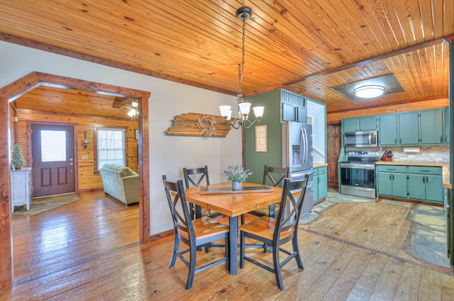 dining space featuring a notable chandelier, light hardwood / wood-style floors, and wood ceiling