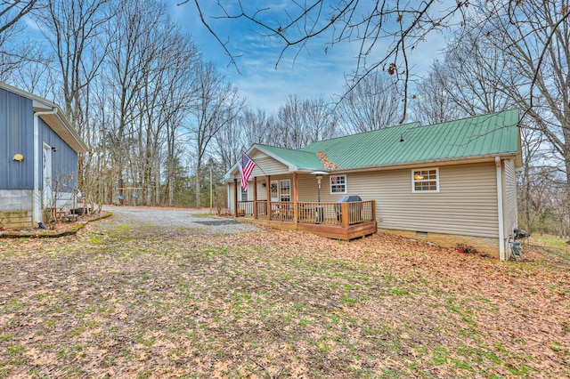 rear view of property with a porch and a deck