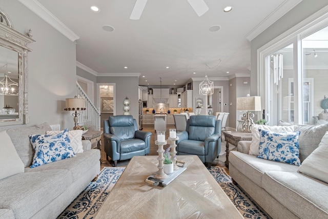 living room featuring ceiling fan with notable chandelier and ornamental molding