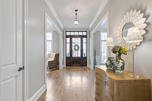 foyer entrance featuring crown molding and hardwood / wood-style flooring