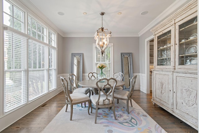 dining area with ornamental molding, dark hardwood / wood-style floors, and a chandelier