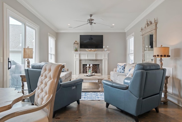 living room featuring ceiling fan, ornamental molding, dark hardwood / wood-style flooring, and a premium fireplace