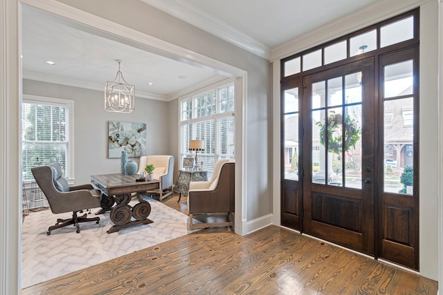 entrance foyer with ornamental molding, an inviting chandelier, and dark hardwood / wood-style flooring