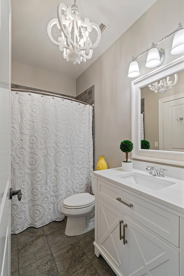 bathroom with vanity, a chandelier, and toilet