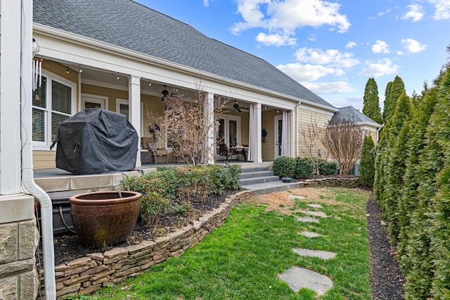 rear view of house with ceiling fan, a patio area, and a lawn