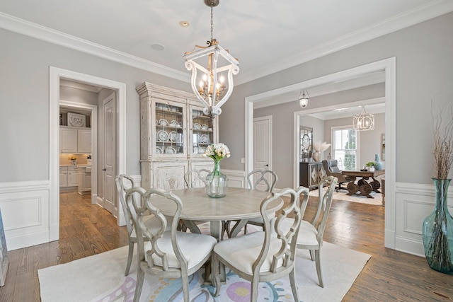 dining room featuring crown molding, dark hardwood / wood-style floors, and a notable chandelier