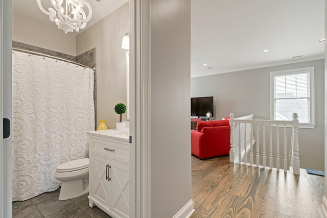 bathroom featuring hardwood / wood-style floors, vanity, toilet, crown molding, and an inviting chandelier