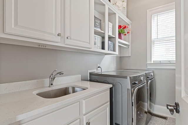 laundry room featuring separate washer and dryer, sink, and cabinets