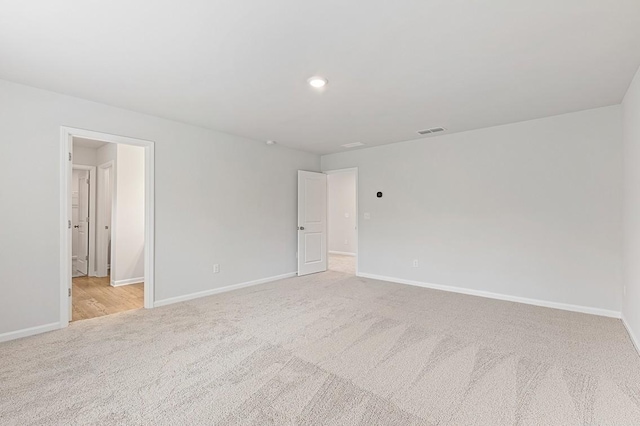 unfurnished room featuring light carpet