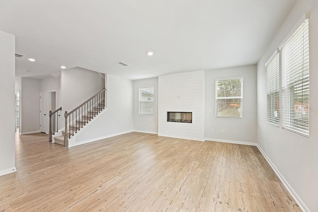 unfurnished living room with light hardwood / wood-style flooring and a fireplace