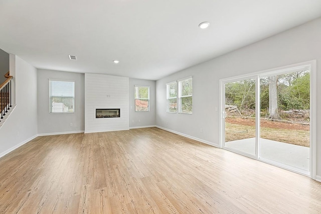 unfurnished living room featuring a fireplace and light hardwood / wood-style flooring