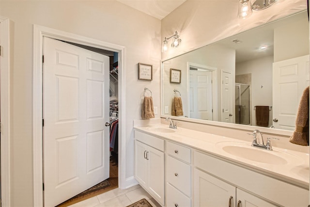 bathroom with tile patterned flooring, vanity, and walk in shower