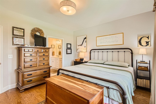 bedroom featuring light hardwood / wood-style flooring and ensuite bathroom