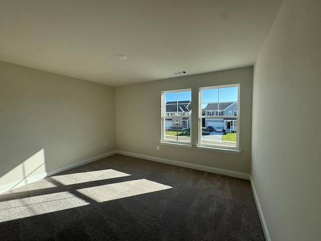 unfurnished room featuring dark carpet