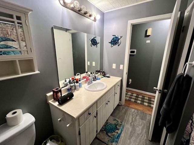 bathroom with vanity, toilet, and hardwood / wood-style floors