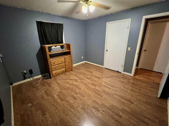 unfurnished bedroom with hardwood / wood-style floors, a textured ceiling, and ceiling fan