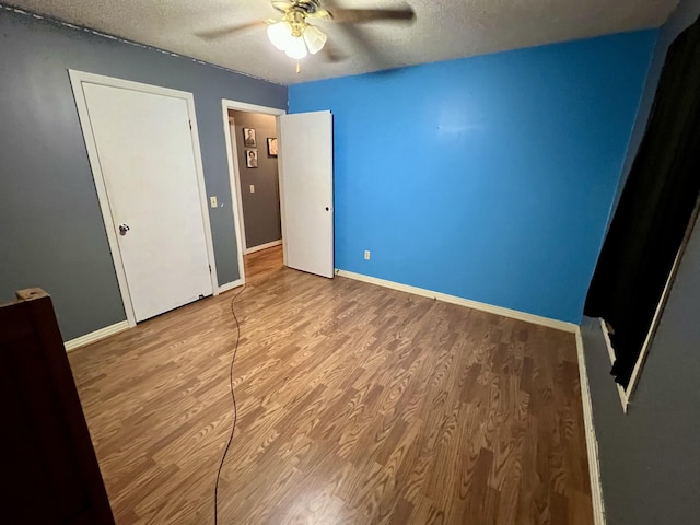 unfurnished bedroom with hardwood / wood-style floors, a textured ceiling, and ceiling fan