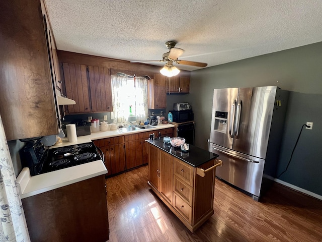 kitchen with black electric range oven, stainless steel fridge with ice dispenser, dark hardwood / wood-style flooring, a kitchen island, and ceiling fan