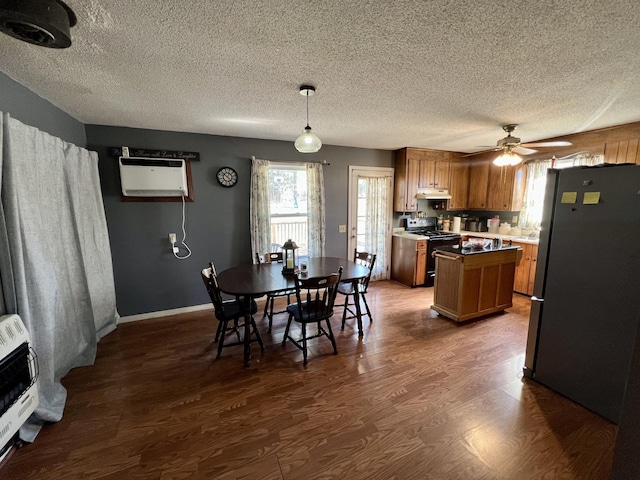 dining area with dark wood-type flooring, ceiling fan, heating unit, a textured ceiling, and an AC wall unit