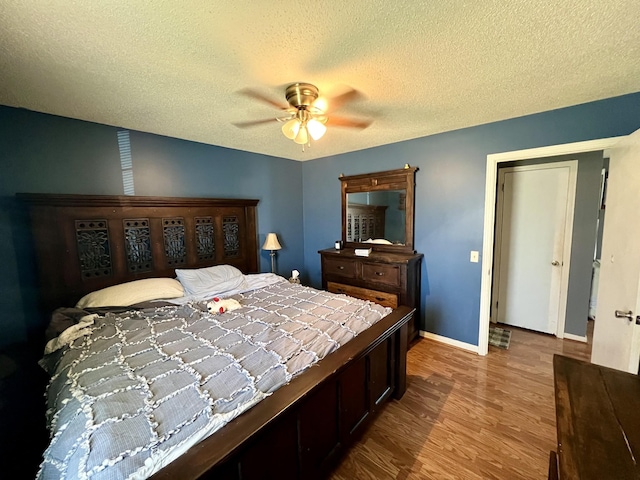 bedroom featuring hardwood / wood-style floors, a textured ceiling, and ceiling fan