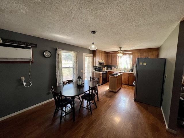 dining area with dark hardwood / wood-style flooring, a wealth of natural light, ceiling fan, and a wall unit AC