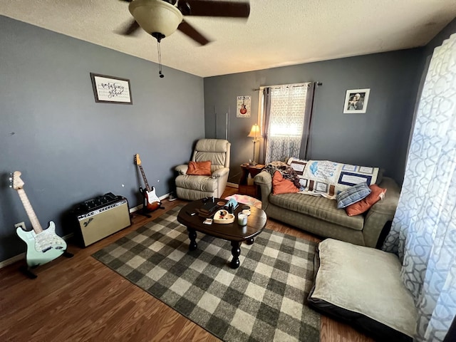 living room with ceiling fan, dark wood-type flooring, and a textured ceiling