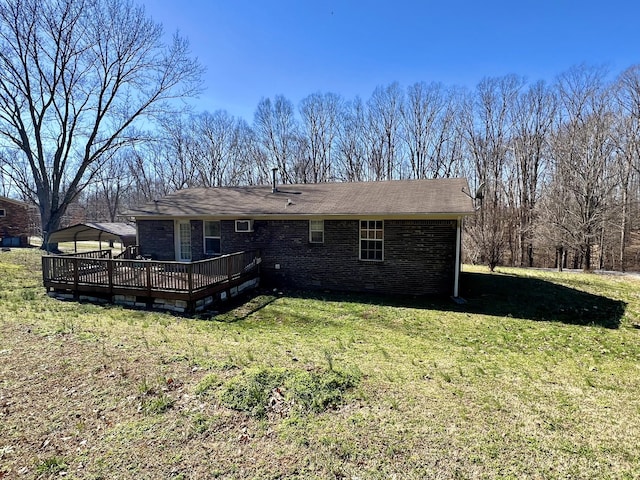 rear view of house with a wooden deck, a yard, and a carport