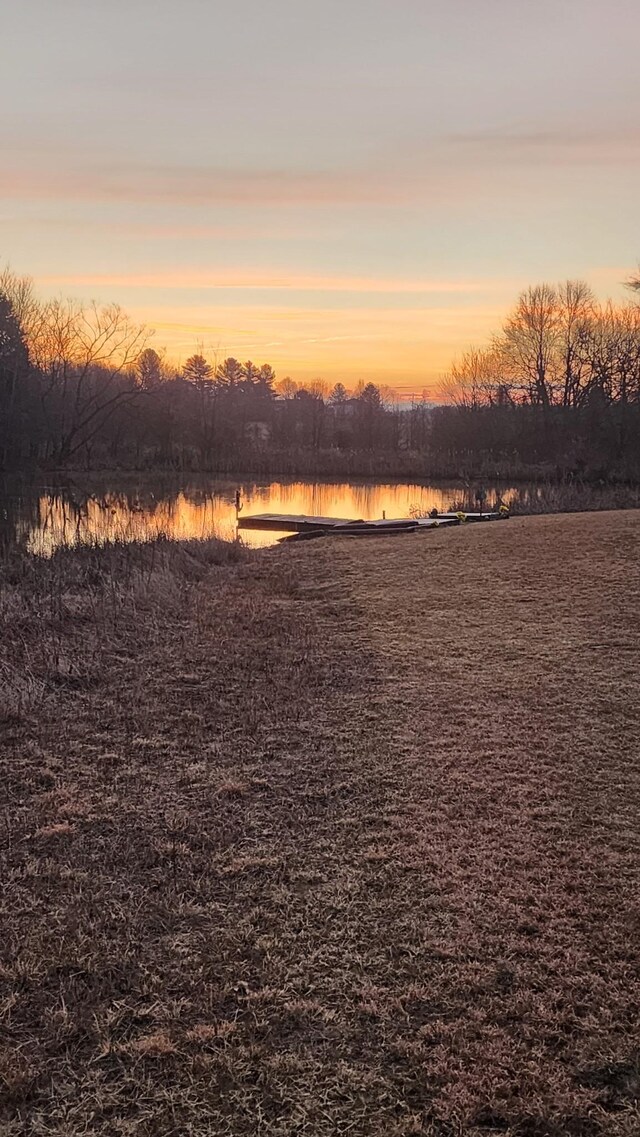 yard at dusk featuring a water view