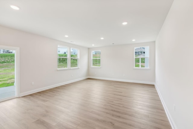 empty room with light wood-style floors, baseboards, and recessed lighting