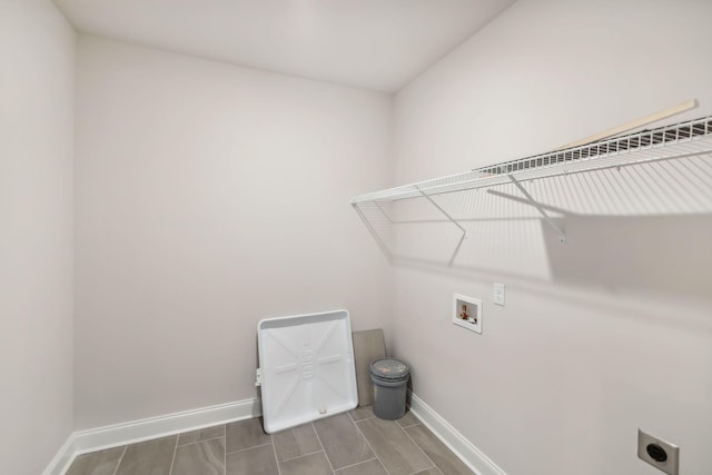 clothes washing area featuring laundry area, hookup for a washing machine, electric dryer hookup, and baseboards