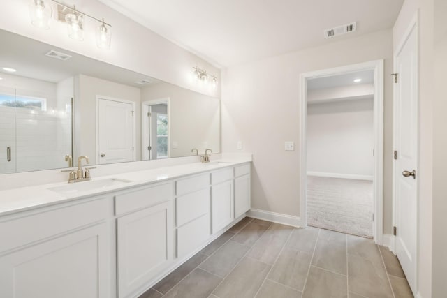 full bathroom with a sink, visible vents, baseboards, double vanity, and a stall shower