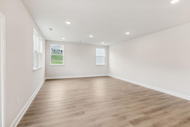 spare room featuring light wood-style flooring, visible vents, baseboards, and recessed lighting