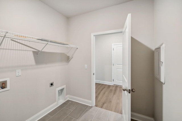 clothes washing area featuring laundry area, washer hookup, electric dryer hookup, and baseboards