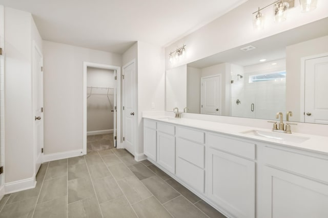 bathroom featuring double vanity, a stall shower, visible vents, and a sink