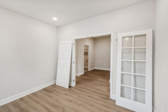 empty room with recessed lighting, light wood-style flooring, and baseboards