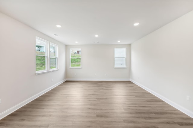 empty room with recessed lighting, baseboards, and wood finished floors