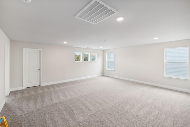 carpeted empty room with recessed lighting, visible vents, and baseboards