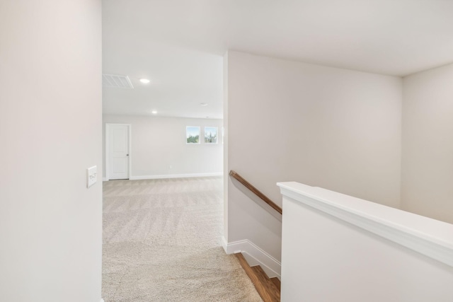 hallway featuring recessed lighting, an upstairs landing, visible vents, baseboards, and carpet