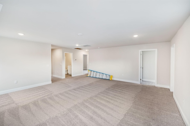 carpeted empty room featuring visible vents, baseboards, and recessed lighting