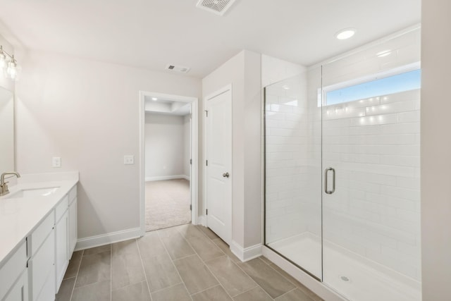 full bath featuring a stall shower, vanity, visible vents, and baseboards