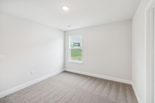 spare room with visible vents, baseboards, and carpet flooring