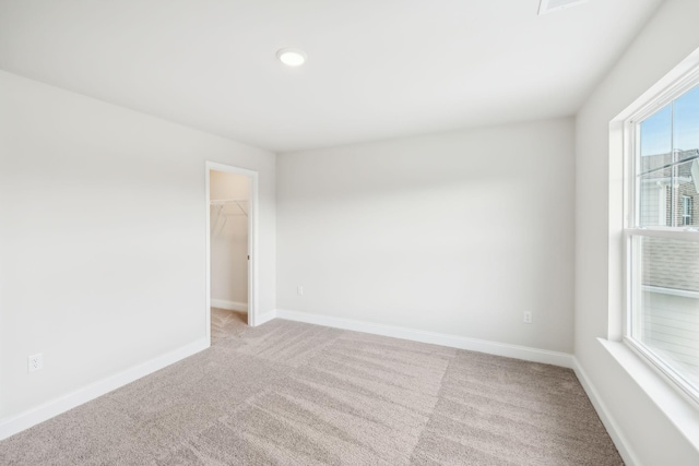 empty room featuring baseboards and light colored carpet