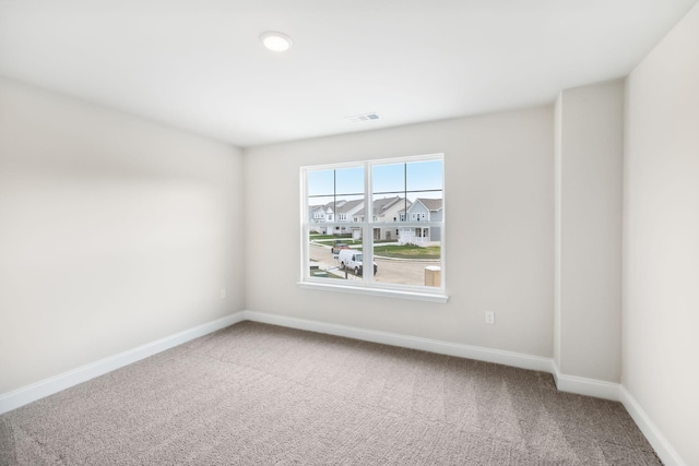 carpeted empty room with visible vents and baseboards