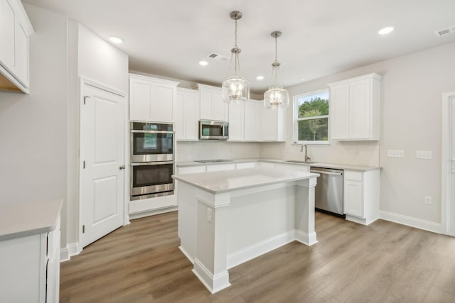 kitchen with light wood-type flooring, visible vents, appliances with stainless steel finishes, and tasteful backsplash