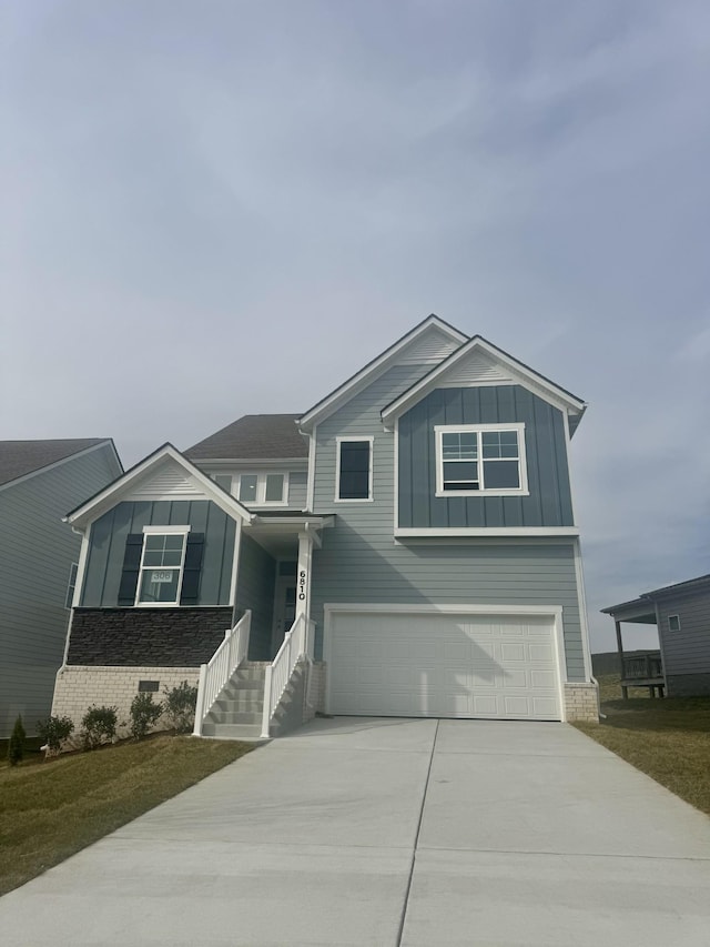 view of front of home featuring brick siding, concrete driveway, an attached garage, board and batten siding, and crawl space